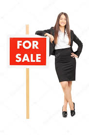 Realtor leaning on a for sale sign